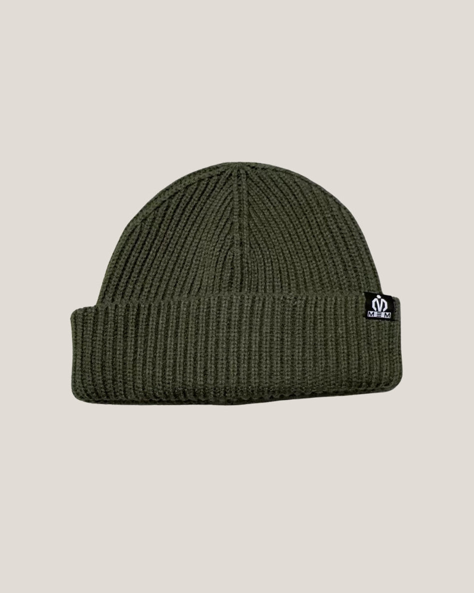 Green beanie with a logo on a beige background
