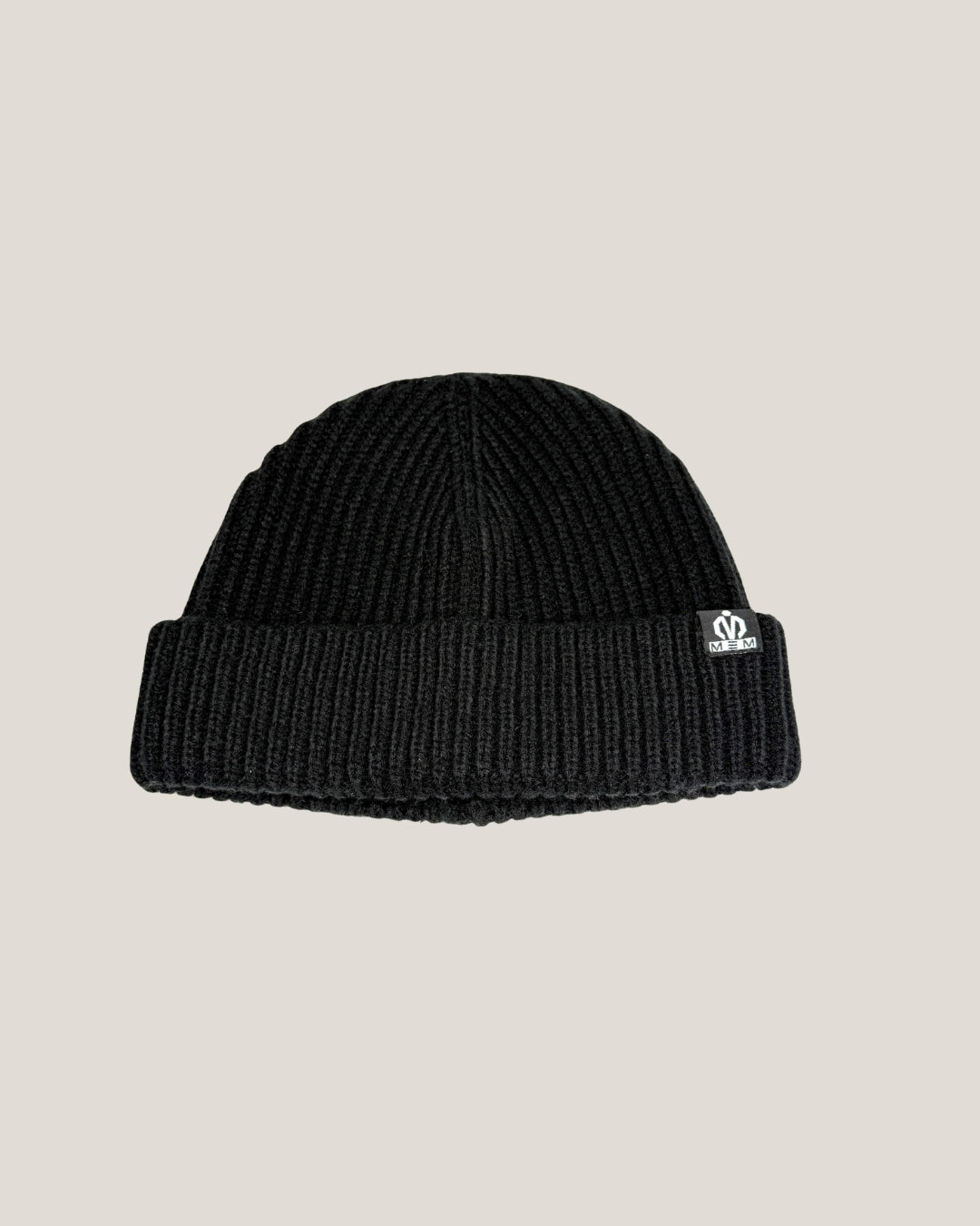 Black beanie with a logo on a beige background