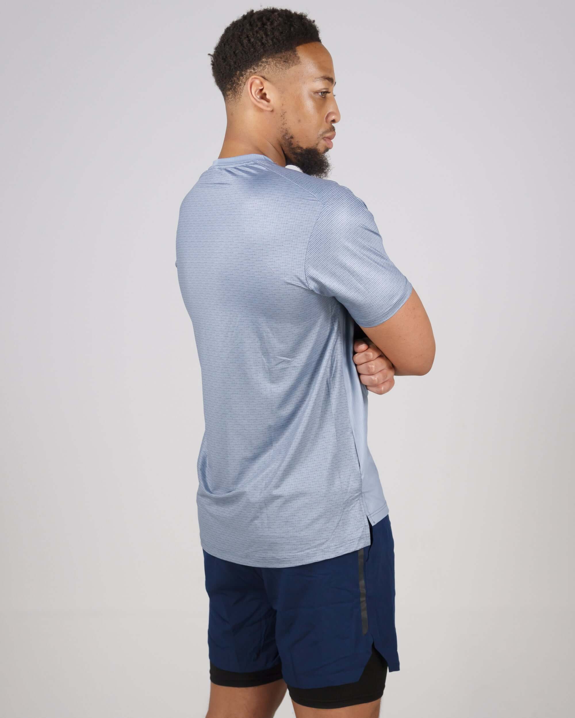 Man wearing blue Pinnacle Dry-Fit T-Shirt, designed with performance technology for optimal training and sweat-wicking comfort.
