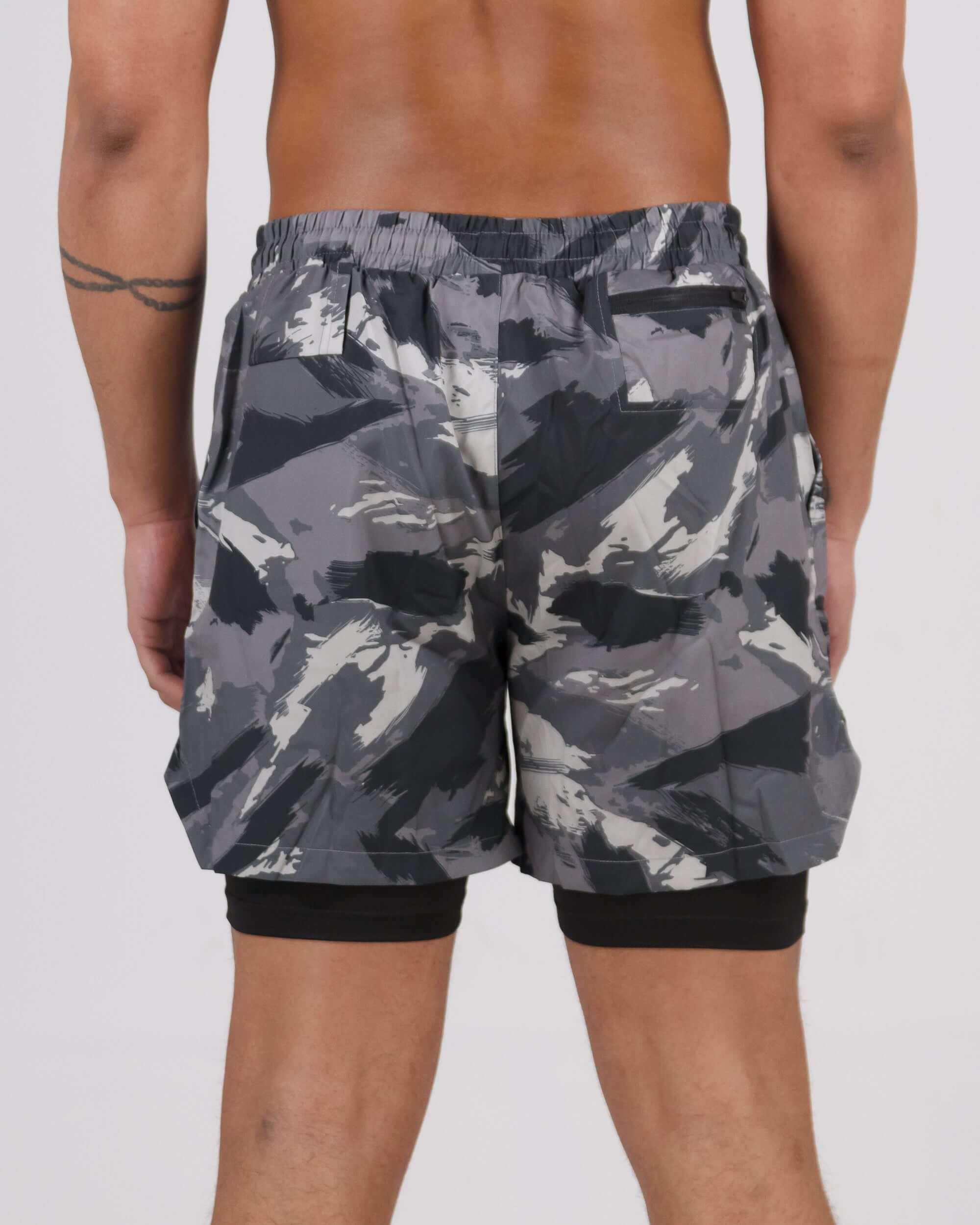 Rear view of grey camouflage Pinnacle Dry-Fit 2-in-1 Shorts with innovative compression design, worn by a male model.